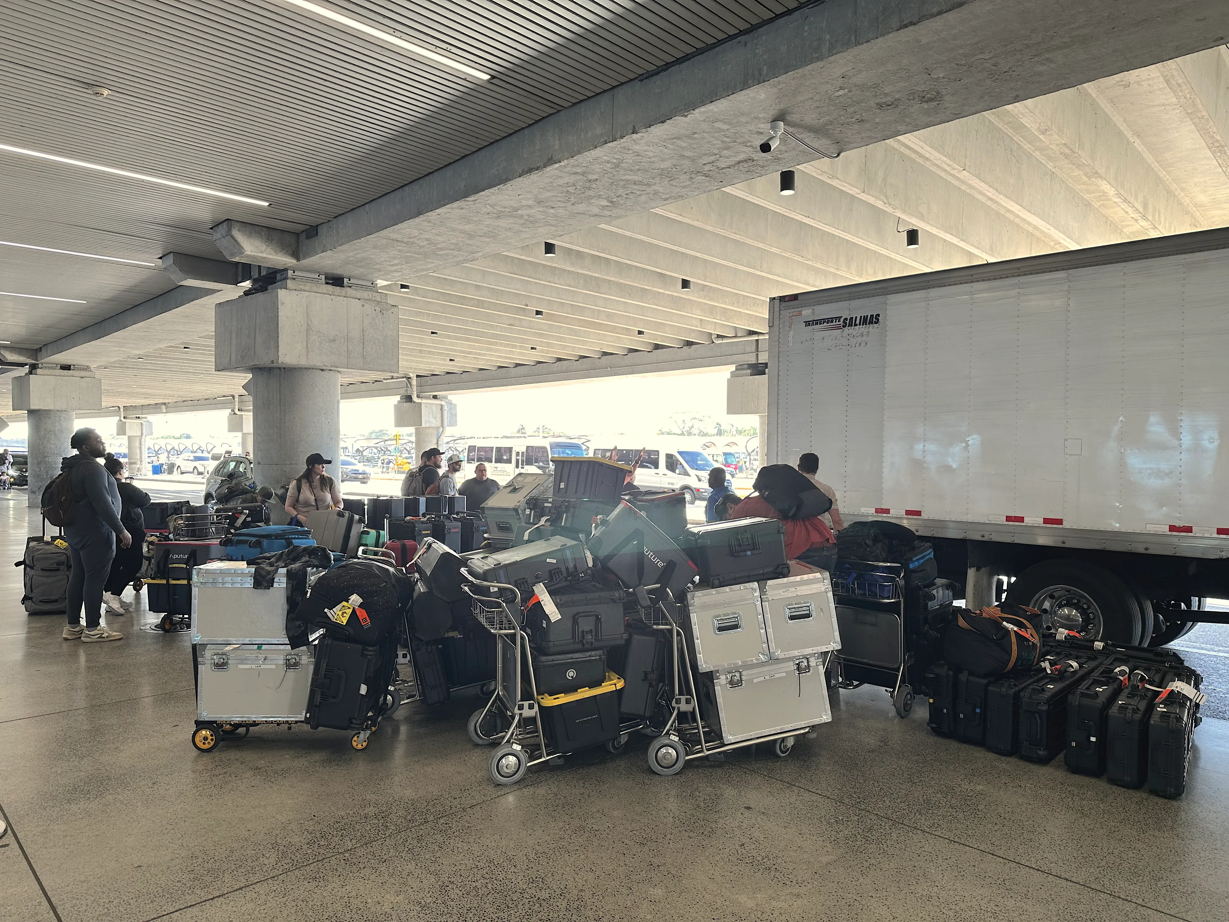 Carts of road cases staged at a loading dock beside a box truck